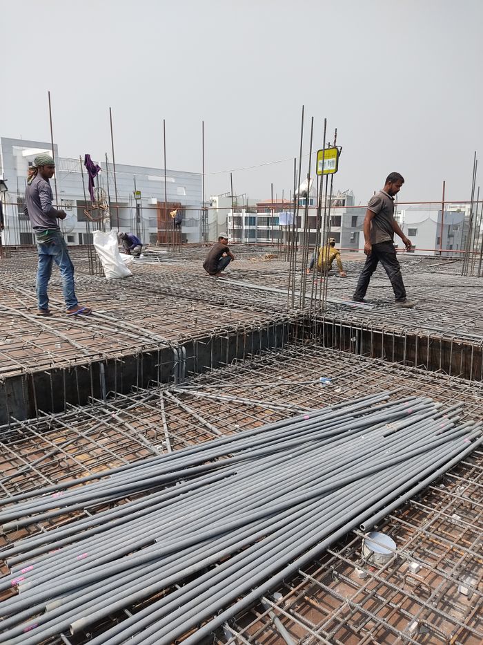 services-04 Workers engaged in construction on a building site, laying metal frameworks.