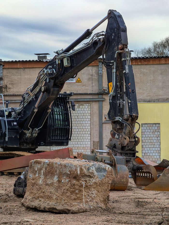 services-img Heavy excavator machinery at a construction site with earth and concrete debris.